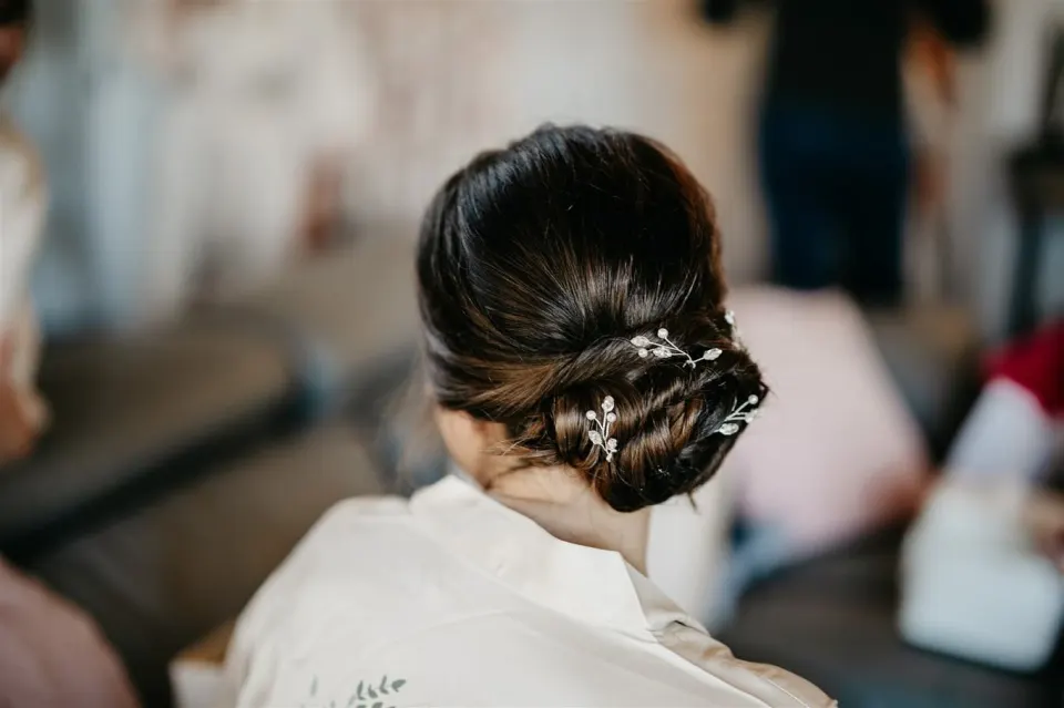 A sleek low twisted chignon with crystal-and-pearl pins